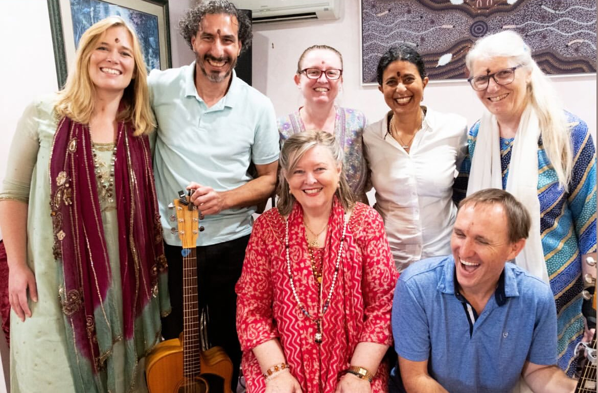 Gayatri smiling with fellow musicians and friends, a guitar in front