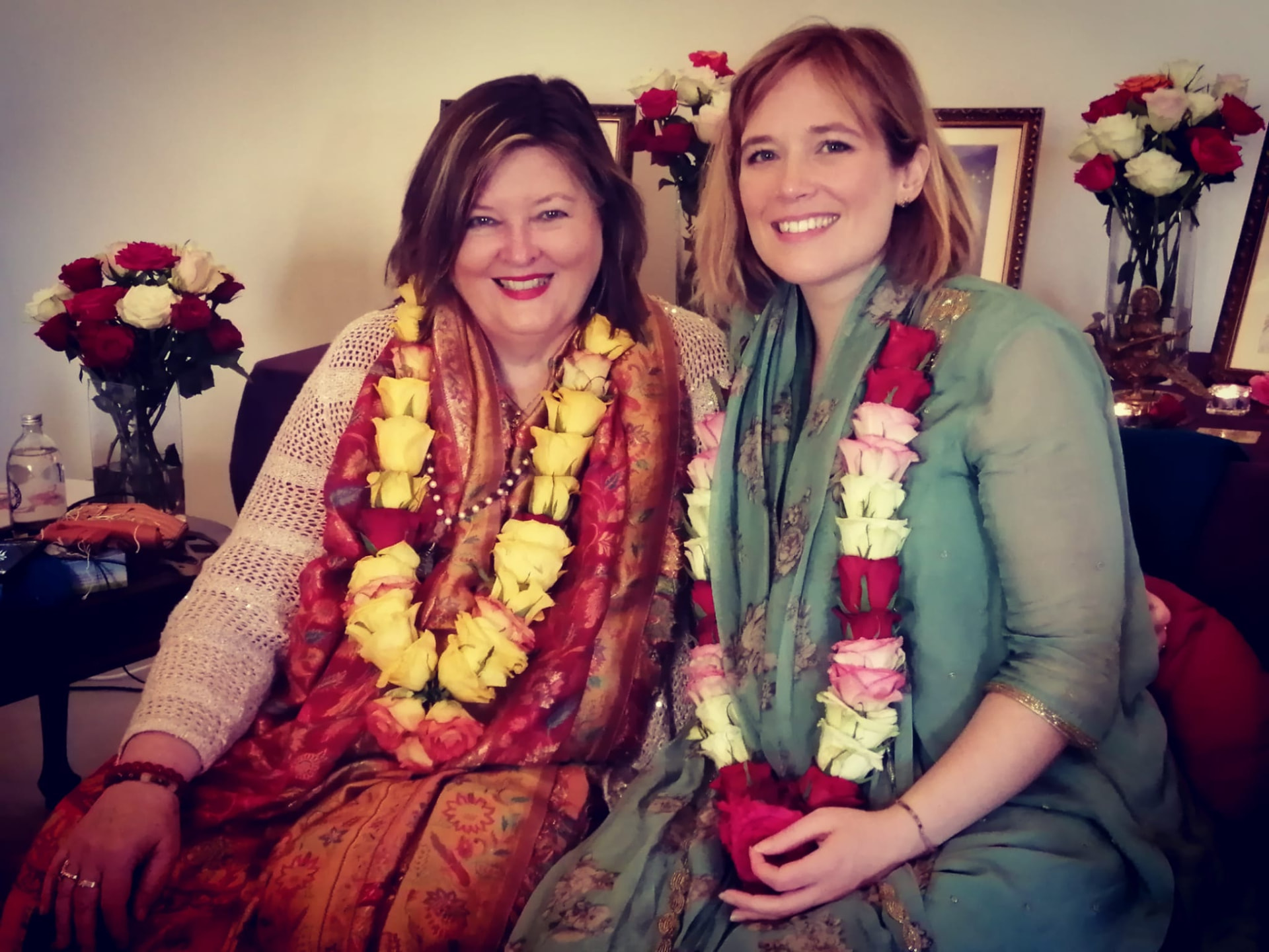Shakti Durga and Gayatri smiling together, wearing rose garlands